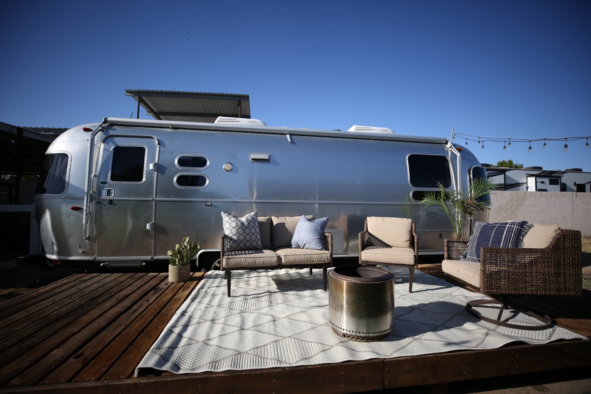 The Airstream lounge with its striped awning extended over deck seating